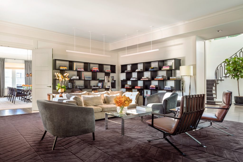 corner of bookshelves in a bright luxury suite with sofa and armchairs