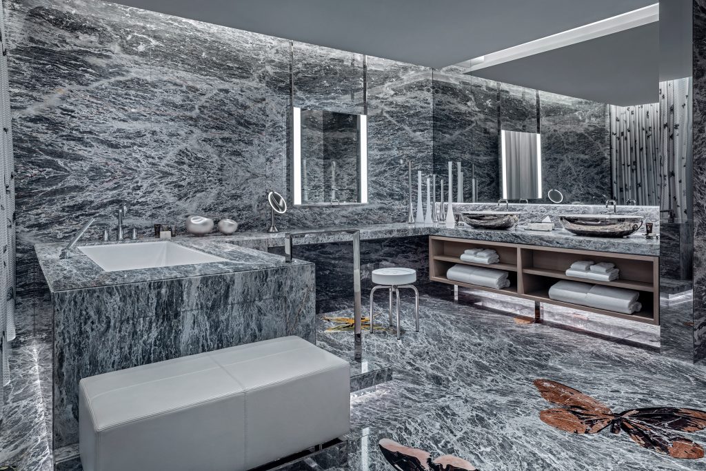 Grey marble bathroom with large bath tub and huge mirrors