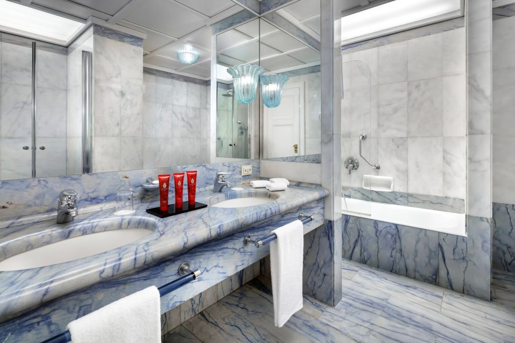 blue marble bathroom with huge mirror and towels