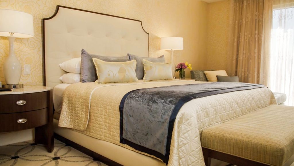 king size bed with cream colored bedspread and with pillows in Bellagio suite