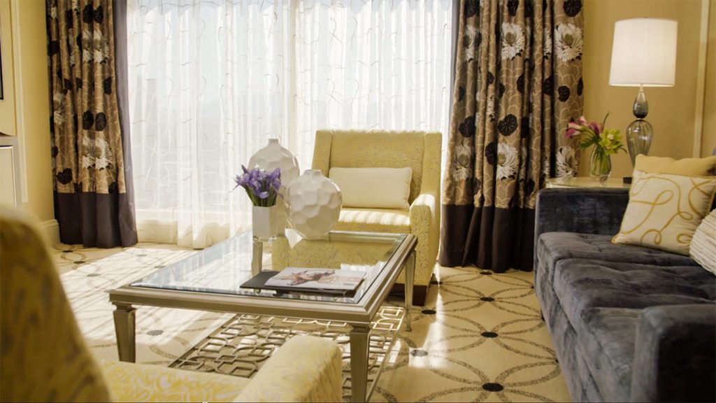 cream color living room in the bellagio suite with curtains one sofa and two armchair