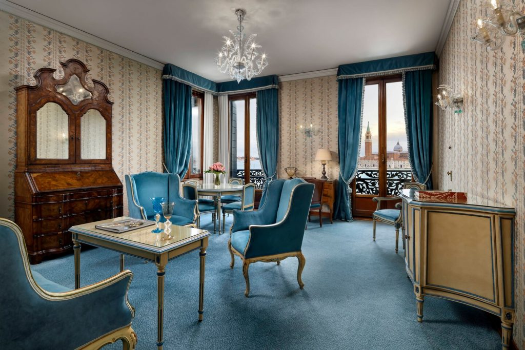 Hotel Danieli large blue living room with chairs and tapestry in the wall blue curtains