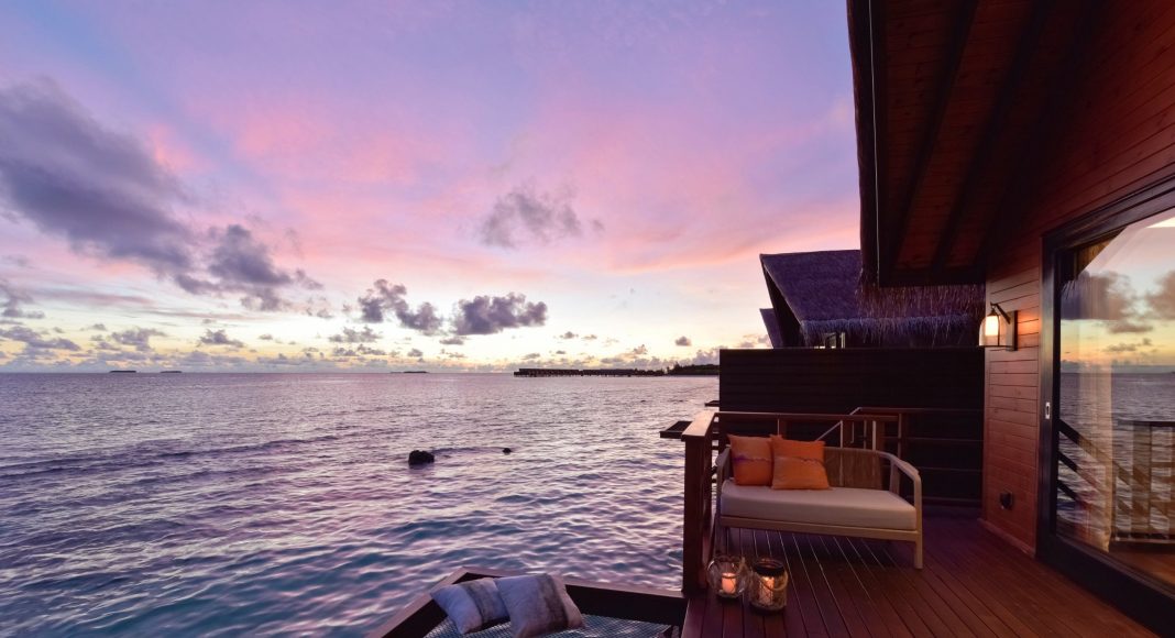 sunset in the Maldives from an overwater villa lovely terrace with wood finishing